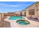 This backyard features a sparkling pool, hot tub, rock landscaping, and ample space for outdoor seating and entertaining at 5224 Red Vine St, North Las Vegas, NV 89031