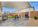 Cozy backyard patio with pavers, a dining set, grill, and a comfortable hanging chair for outdoor relaxation at 5479 Tamar Ridge Ct, Las Vegas, NV 89141