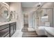 Bright bathroom featuring a walk-in shower, double sinks, and modern vanity at 5479 Tamar Ridge Ct, Las Vegas, NV 89141