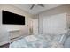 This bedroom features a ceiling fan, large TV, and closet with sliding doors at 5479 Tamar Ridge Ct, Las Vegas, NV 89141
