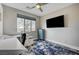 Home office features a ceiling fan, large window, TV, and a blue accent cabinet at 5479 Tamar Ridge Ct, Las Vegas, NV 89141