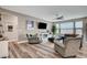 Cozy living room with comfortable seating, a modern ceiling fan, and large windows at 5479 Tamar Ridge Ct, Las Vegas, NV 89141