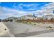 A sunny street view showcasing new, modern homes in a well-maintained neighborhood with flags at 5479 Tamar Ridge Ct, Las Vegas, NV 89141