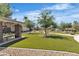This well-manicured community space has a green lawn, trees, and a covered area for picnics and gatherings at 6160 Majestic Wind Ave, Las Vegas, NV 89122