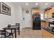 Eat-in kitchen features tile flooring, wood cabinetry, black appliances, and ample storage at 6160 Majestic Wind Ave, Las Vegas, NV 89122