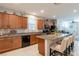 Spacious kitchen featuring wood cabinets, granite counters, stainless steel appliances and an island with bar seating at 6317 Highledge St, North Las Vegas, NV 89081