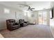 Spacious living room with large windows, neutral paint, ceiling fan and carpet flooring at 6317 Highledge St, North Las Vegas, NV 89081