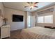 Cozy bedroom featuring a large window, neutral walls, carpet flooring and a ceiling fan at 6317 Highledge St, North Las Vegas, NV 89081