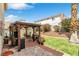 This backyard features a shaded gazebo with chairs, flowers, and a privacy fence at 6440 High Sierra Ave, Las Vegas, NV 89156