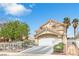 Two-story home with a red tile roof, white iron fence, arched entryway, and a well-maintained landscape at 6440 High Sierra Ave, Las Vegas, NV 89156
