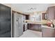 Well lit kitchen features a stainless steel refrigerator and updated dark brown cabinets at 6440 High Sierra Ave, Las Vegas, NV 89156