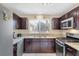 Updated kitchen showcasing granite countertops, stainless steel appliances, and dark brown cabinets at 6440 High Sierra Ave, Las Vegas, NV 89156