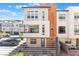Modern three-story home with a balcony, desert landscaping, and a mix of white and tan exterior finishes at 647 Spotted Falcon St, Las Vegas, NV 89138