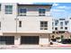 A modern three-story townhouse with black garage doors and a neutral-colored facade at 647 Spotted Falcon St, Las Vegas, NV 89138