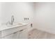 Bright laundry room features a sink, chrome faucet, and sleek white cabinets at 647 Spotted Falcon St, Las Vegas, NV 89138