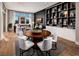 Open-concept living area with stylish furniture, a feature wall with shelving, and hardwood flooring at 647 Spotted Falcon St, Las Vegas, NV 89138