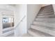 Staircase featuring carpeted steps and a white railing, with natural light from nearby windows at 647 Spotted Falcon St, Las Vegas, NV 89138