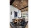Contemporary dining room with wood-beamed ceilings, shiplap walls, modern lighting, and a decorative patterned rug at 654 Agate Bridge St, Las Vegas, NV 89138
