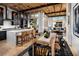 Bright dining room with wood-beamed ceilings, modern lighting, and an open floor plan flowing into the kitchen and living area at 654 Agate Bridge St, Las Vegas, NV 89138