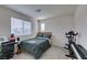 Cozy bedroom with carpeted floor, a bed, a desk, and workout equipment near window at 6804 Sage Gold Ct, North Las Vegas, NV 89086