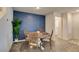 Cozy dining area with wood table and chairs, a plant, and a blue accent wall at 6804 Sage Gold Ct, North Las Vegas, NV 89086