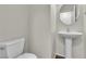 This powder room includes a toilet and pedestal sink with a round mirror above at 7632 Calico Fields St, Las Vegas, NV 89149