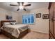Bedroom with light carpet, a ceiling fan, and a bed with shuttered window behind it at 8396 Garnet Canyon Ln, Las Vegas, NV 89129