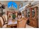Formal dining room with grand chandelier, large windows, and ornate wood furnishings at 8396 Garnet Canyon Ln, Las Vegas, NV 89129