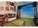 Indoor golf simulator room with a fireplace and comfortable seating provides a perfect space for practice and entertainment at 8396 Garnet Canyon Ln, Las Vegas, NV 89129