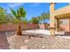 Landscaped backyard features decorative rock, a small palm tree, and a concrete patio at 8453 Cheerful Brook Ave, Las Vegas, NV 89143