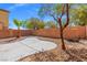 Backyard features desert landscaping, decorative rock, a patio, mature trees, and block wall at 8453 Cheerful Brook Ave, Las Vegas, NV 89143