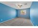 Bedroom features a window with views of trees, carpet flooring, and a ceiling fan at 8453 Cheerful Brook Ave, Las Vegas, NV 89143