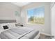 Virtually staged primary bedroom featuring large window, a tufted headboard, and neutral tones at 913 Duckhorn Ct # 201, Las Vegas, NV 89144