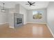 Open living room featuring hard wood floors, brick fireplace, ceiling fan and view into kitchen at 913 Duckhorn Ct # 201, Las Vegas, NV 89144