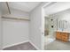 Spacious walk-in closet adjacent to a bathroom with a marble tiled shower with a glass surround at 913 Duckhorn Ct # 201, Las Vegas, NV 89144