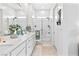 All-white bathroom featuring double sinks, white cabinets, a glass shower, and decorative towels at 916 Belleforte Ln, Las Vegas, NV 89138