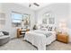 Bright bedroom featuring a ceiling fan, large windows, a study desk, and a cozy armchair at 916 Belleforte Ln, Las Vegas, NV 89138