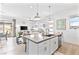 Modern kitchen open to living room, features stainless appliances, quartz countertops, and breakfast bar with seating at 916 Belleforte Ln, Las Vegas, NV 89138