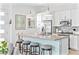 Modern kitchen features white cabinets, stainless appliances, breakfast bar with stools, and bright lighting at 916 Belleforte Ln, Las Vegas, NV 89138