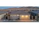 Home exterior with a two car garage, stone accents, and a private, fenced backyard at 916 Belleforte Ln, Las Vegas, NV 89138