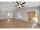Bright living room with vaulted ceilings, wood floors, ceiling fan and sliding glass doors to backyard at 9513 Yucca Blossom Dr, Las Vegas, NV 89134