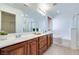 Bright bathroom featuring dual vanities, large mirror, soaking tub, and separate shower at 953 Wagner Valley St, Henderson, NV 89052