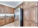 Kitchen features stainless steel refrigerator, wood cabinetry, granite countertops, and hardwood flooring at 953 Wagner Valley St, Henderson, NV 89052