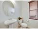 Clean powder room featuring a pedestal sink, toilet, and window with privacy blinds at 953 Wagner Valley St, Henderson, NV 89052