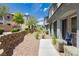 Landscaped walkway leads to the townhome entrance, featuring decorative rock, retaining wall and well-maintained bushes at 965 Nevada State Dr # 35101, Henderson, NV 89002