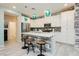 This kitchen has an island with bar stool seating, white cabinets, stainless appliances, and modern countertops at 965 Nevada State Dr # 35101, Henderson, NV 89002