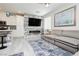 Open-concept living area with a sectional sofa, electric fireplace, TV, stylish kitchen, and modern decor at 965 Nevada State Dr # 35101, Henderson, NV 89002