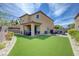 Lush backyard with a covered patio, ample green space, and comfortable seating areas for entertaining at 9990 Perth Ct, Las Vegas, NV 89141