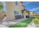 Inviting backyard featuring a covered patio, green space, and seating area perfect for outdoor relaxation at 9990 Perth Ct, Las Vegas, NV 89141