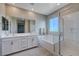 Bright bathroom featuring a double vanity, soaking tub, and glass-enclosed shower, creating a relaxing spa-like atmosphere at 9990 Perth Ct, Las Vegas, NV 89141